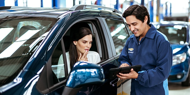 Asesor de servicio Chevrolet explicando detalles de mantenimiento