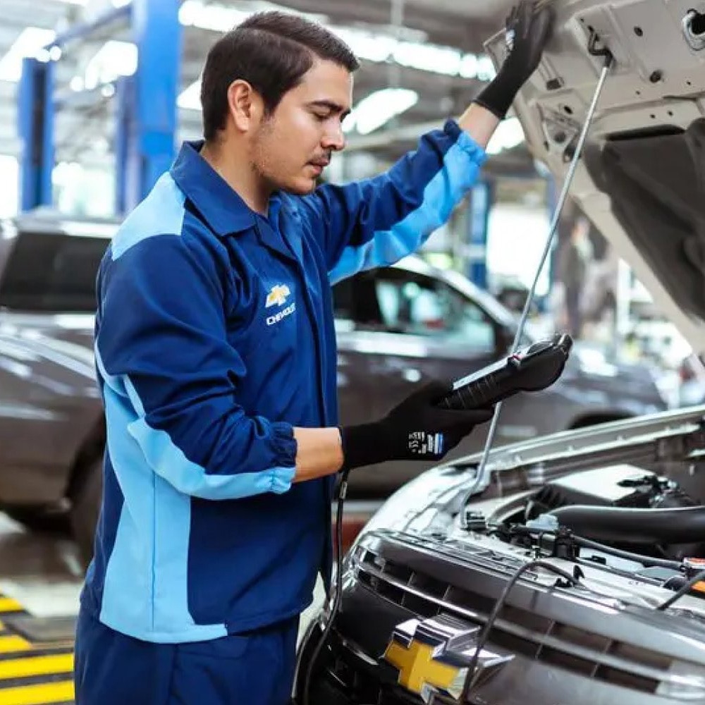Hombre inspeccionando el motor de un carro